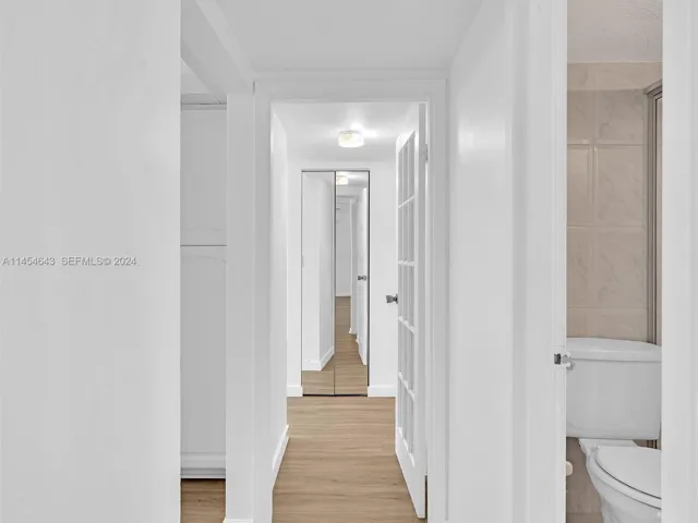 Clean lines leading from living-dingin area down hall to primary bedroom