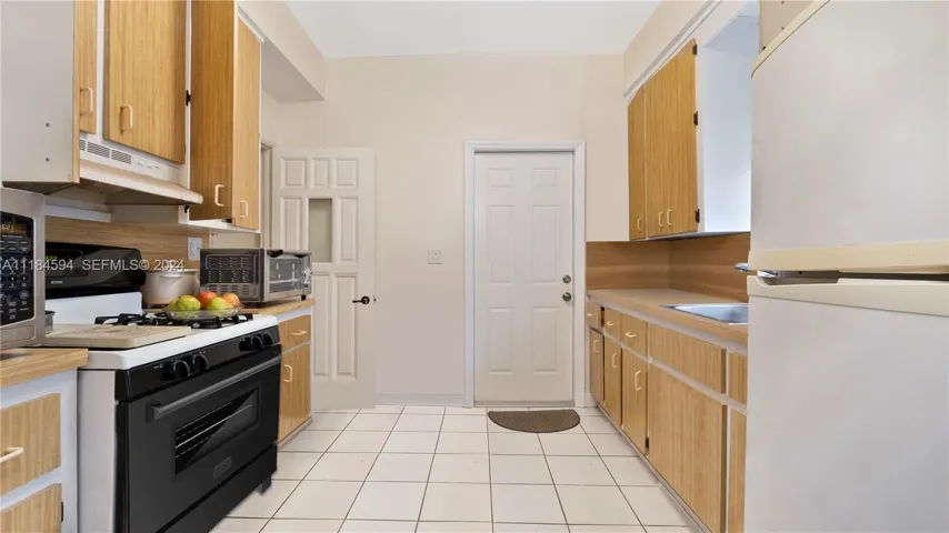 Galley style kitchen with access to the backyard and outdoor covered laundry room