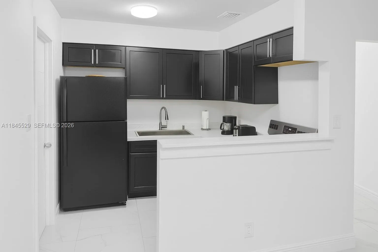 Newer shaker cabinets & open concept kitchen with coffee counter connects living/dining/kitchen space