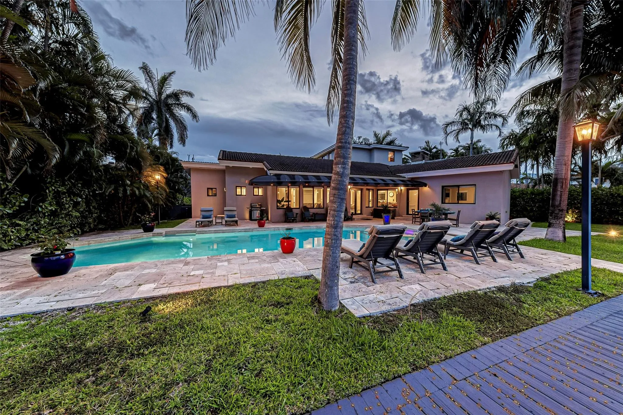 Waterfront backyard with heated pool and lounge area overlooking the canal