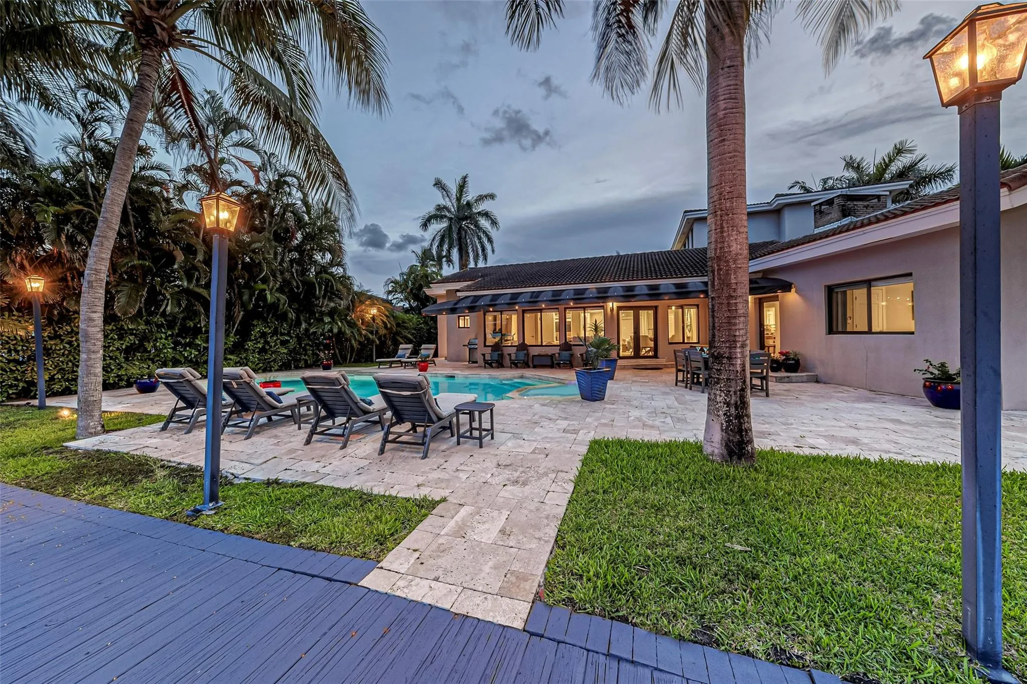 Waterfront backyard with heated pool and lounge area overlooking the canal