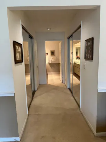 Two large walk-in closets with glass doors, leading towards master bathroom