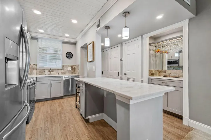 Updated and open kitchen boasts shaker style cabinets, quartz countertops and stainless steel appliances