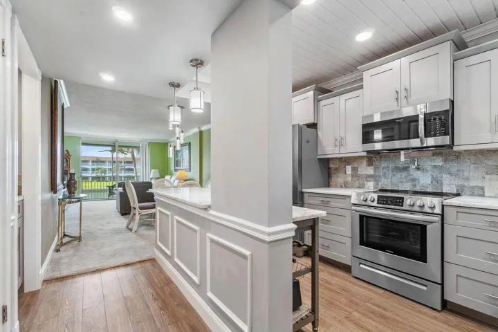 Updated and open kitchen boasts shaker style cabinets, quartz countertops and stainless steel appliances
