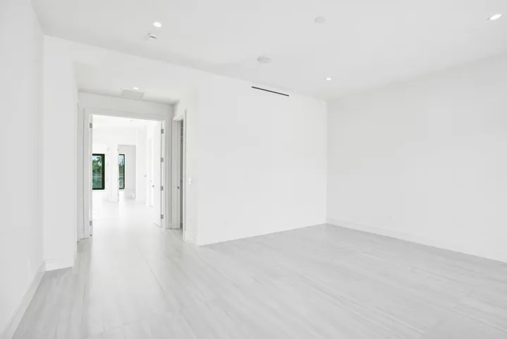 Expansive primary retreat occupying nearly half of the second floor, featuring high ceilings, modern linear A/C vents, dual walk-in closets, and an oversized east-facing covered balcony and east-facing covered balcony with TV and spa connections.