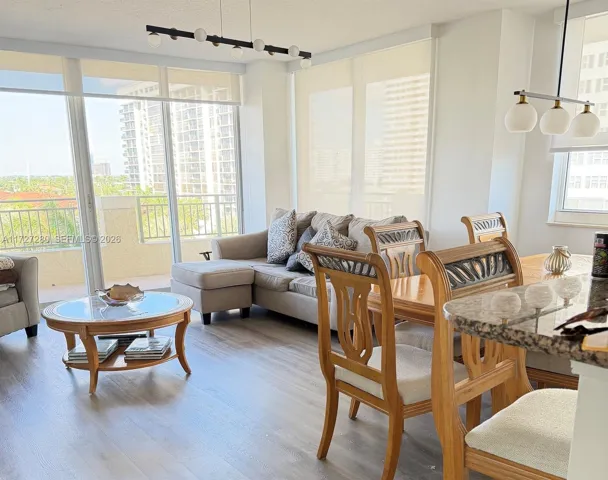 Living Room and Dining Room open floor combination. Balcony facing the city and the Ocean