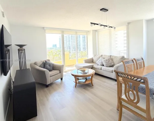 Spacious Living area with natural light, balcony access, and OCEAN AND CITY VIEWS.