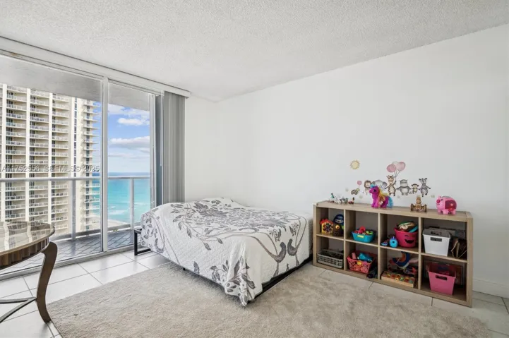 2nd Bedroom with Balcony & Ocean Views w/ Built Out Closet and Entrance to Bathroom.
