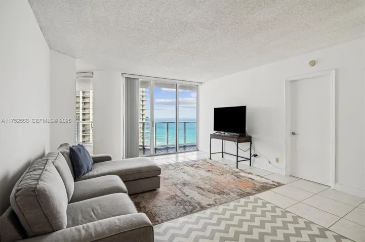 Open Layout Living Area with Entrance to Balcony.