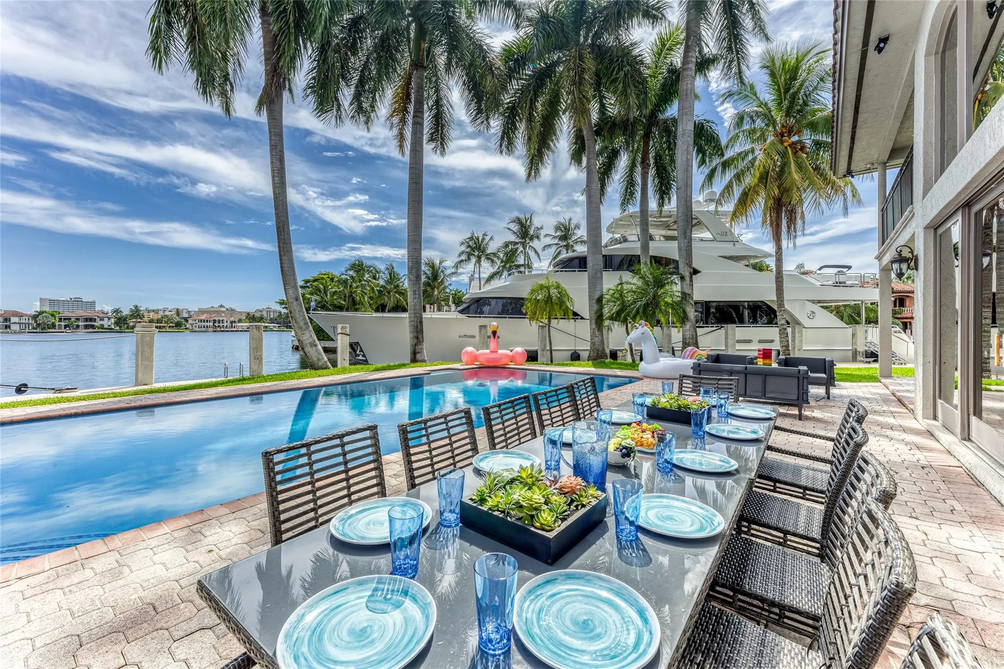 Outdoor waterfront Point Lot with pool area with outdoor dining, lounge chairs, BBQ & siting area.