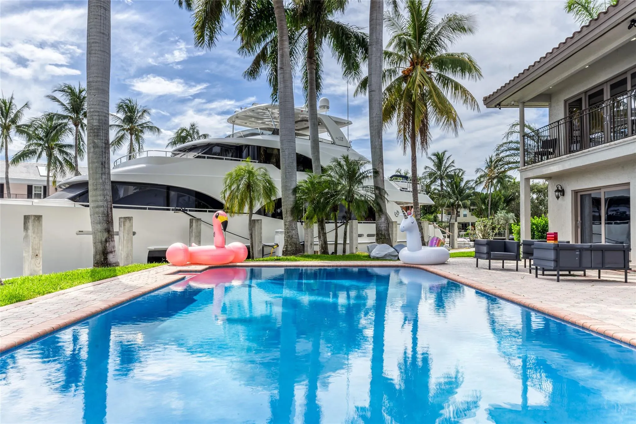 Outdoor waterfront Point Lot with pool area with outdoor dining, lounge chairs, BBQ & siting area.