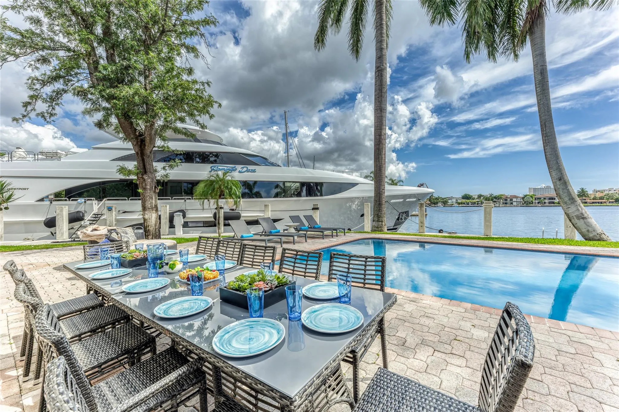 Outdoor waterfront Point Lot with pool area with outdoor dining, lounge chairs, BBQ & siting area.