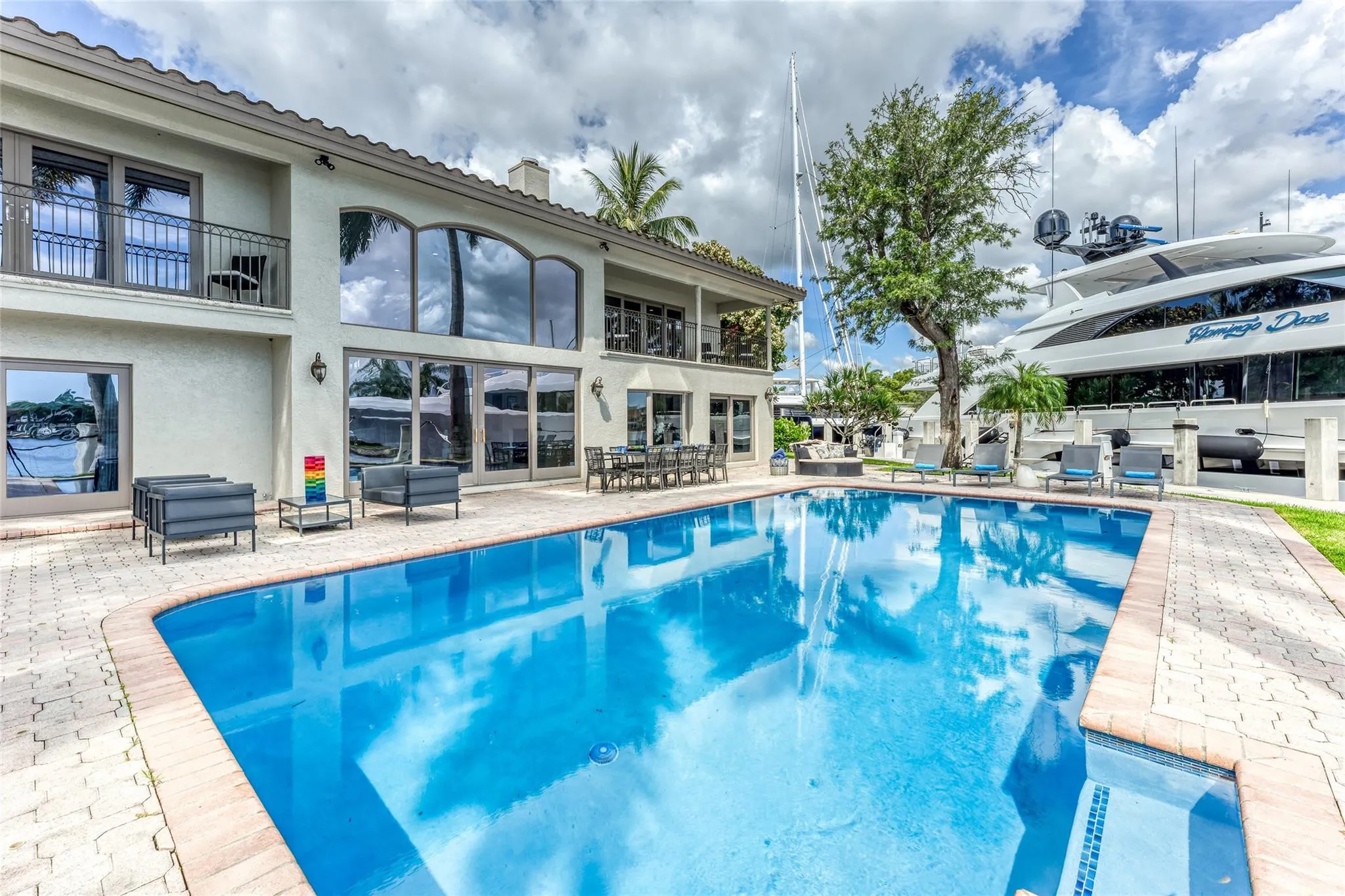 Outdoor waterfront Point Lot with pool area with outdoor dining, lounge chairs, BBQ & siting area.