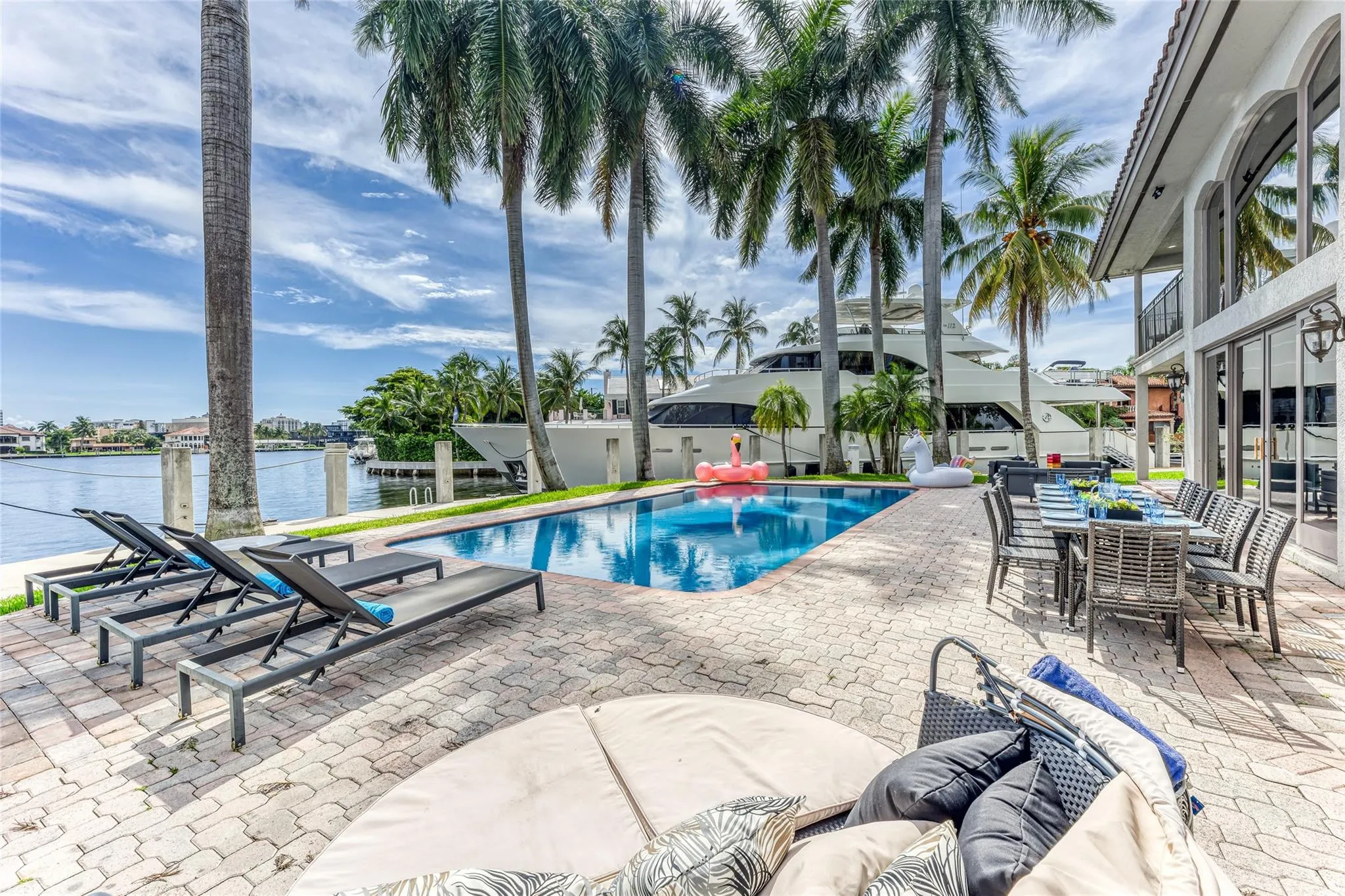 Outdoor waterfront Point Lot with pool area with outdoor dining, lounge chairs, BBQ & siting area.
