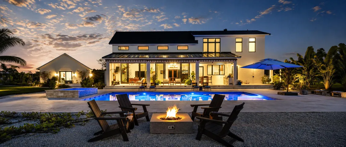 Twilight luxury home with glowing pool