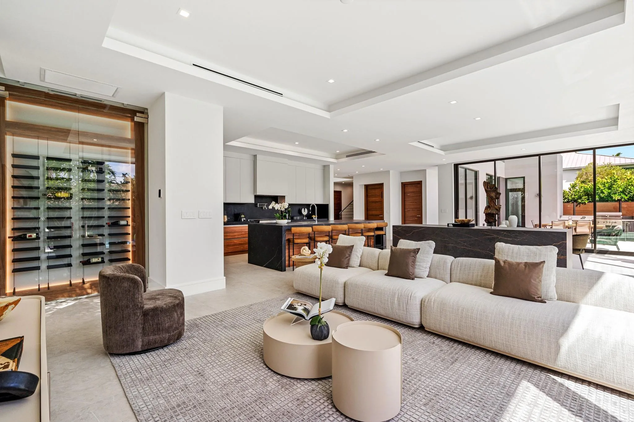 A refined open living area featuring clean architectural lines, custom millwork, and a seamless transition into the designer kitchen beyond. Bright and impeccably styled, this contemporary space is crafted for relaxed luxury and effortless entertaining.