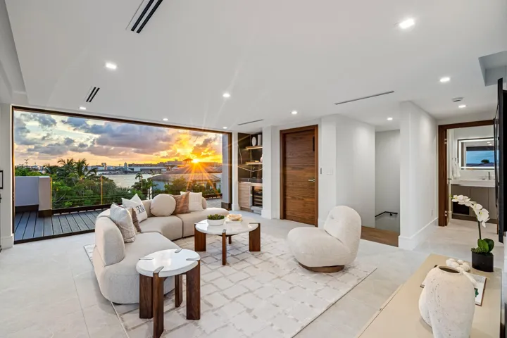 A spectacular third-floor sky lounge wrapped in floor-to-ceiling glass, capturing stunning sunset views over the water and city beyond. Elevated and dramatic, this sophisticated retreat is designed for unforgettable evenings and refined entertaining above it all.
