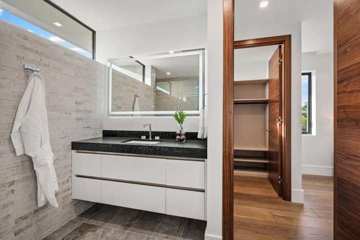 A sleek contemporary bath featuring a floating vanity with integrated lighting, minimalist hardware, and crisp modern finishes. Clean, bright, and thoughtfully designed, this elegant space delivers understated luxury with spa-inspired appeal.