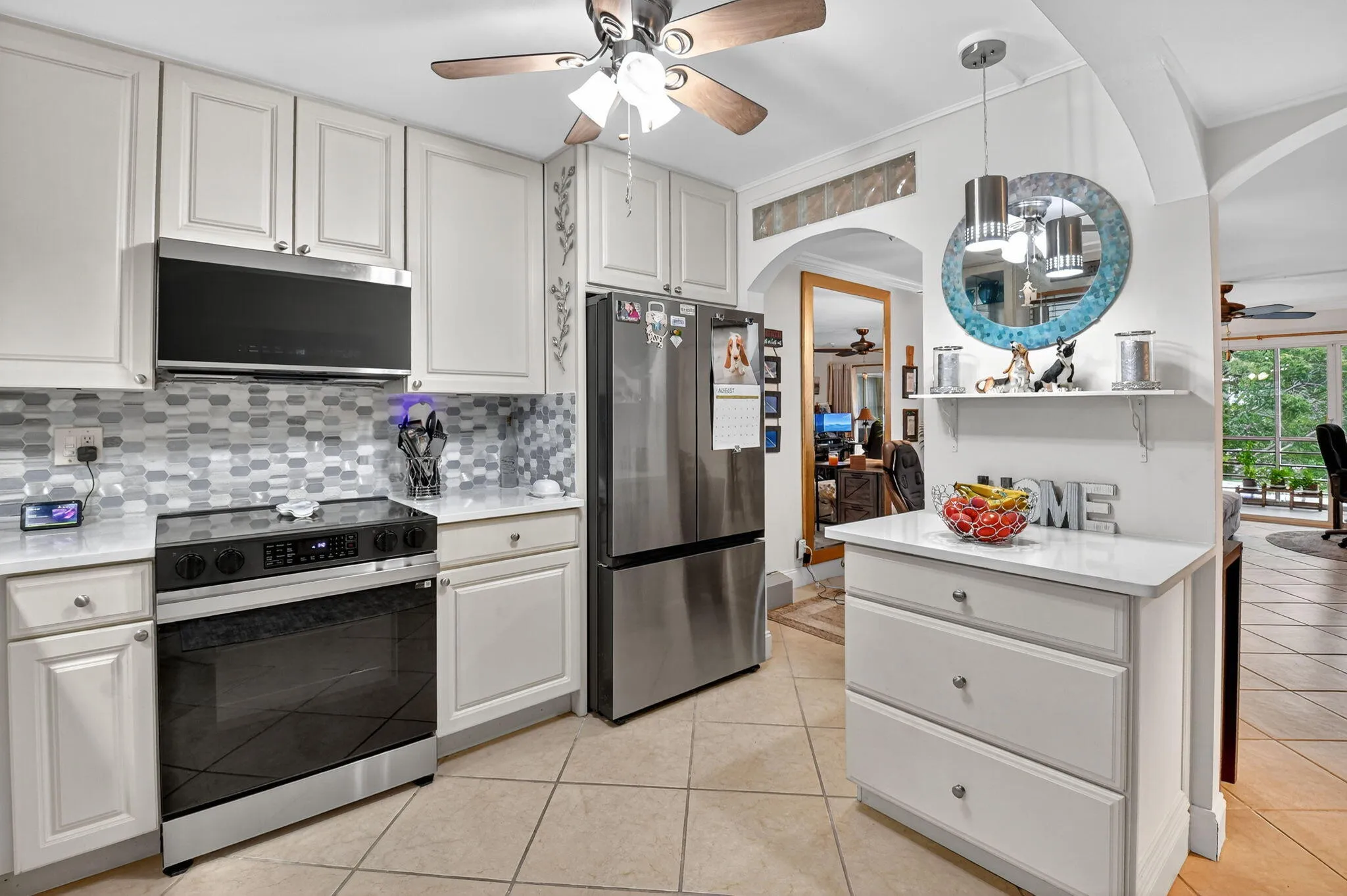 Neutral Cabinets and Counters w/stylish backsplash, pendant lighting and lighted glass cabinets