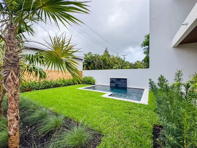 (as of April 8, 2026) view of spa pool and backyard from patio, clusia grows quickly and will be taller than fence by end of year