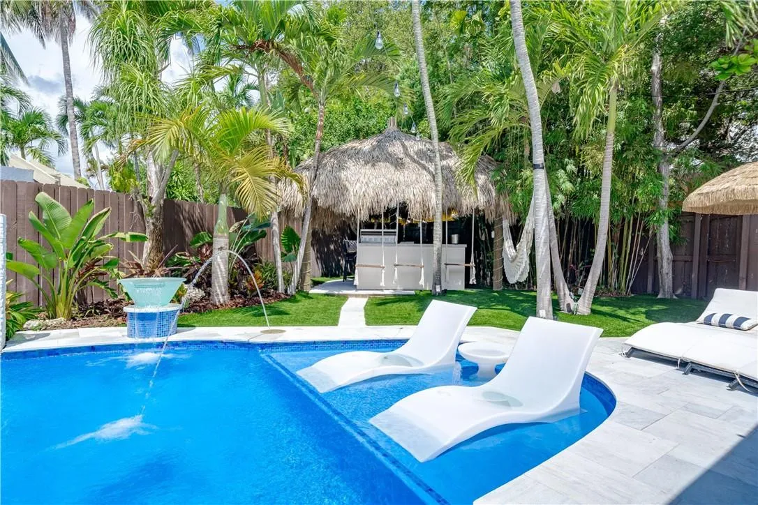 2 lounge chairs and center table inside of the pool to enjoy a cocktail under the sun