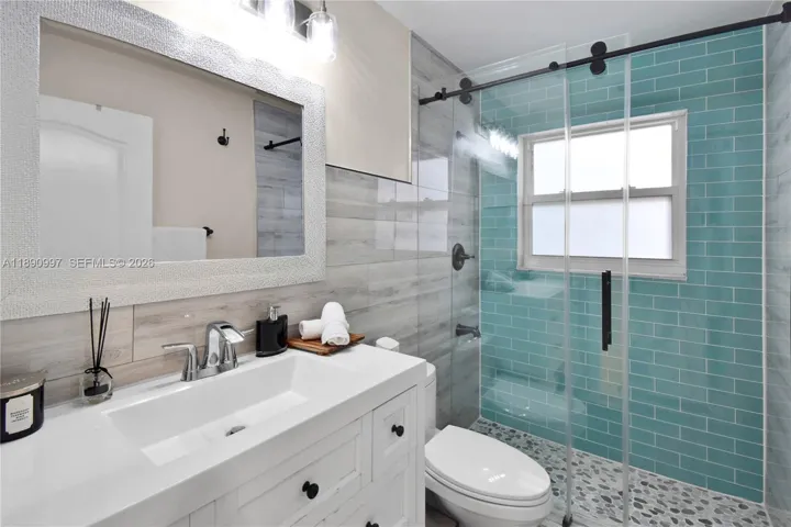 Updated bathroom with new vanity and fixtures, and glass-enclosed shower