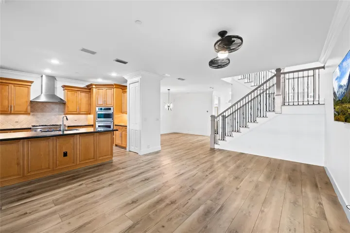 Entertainment area with view of kitchen and stairs