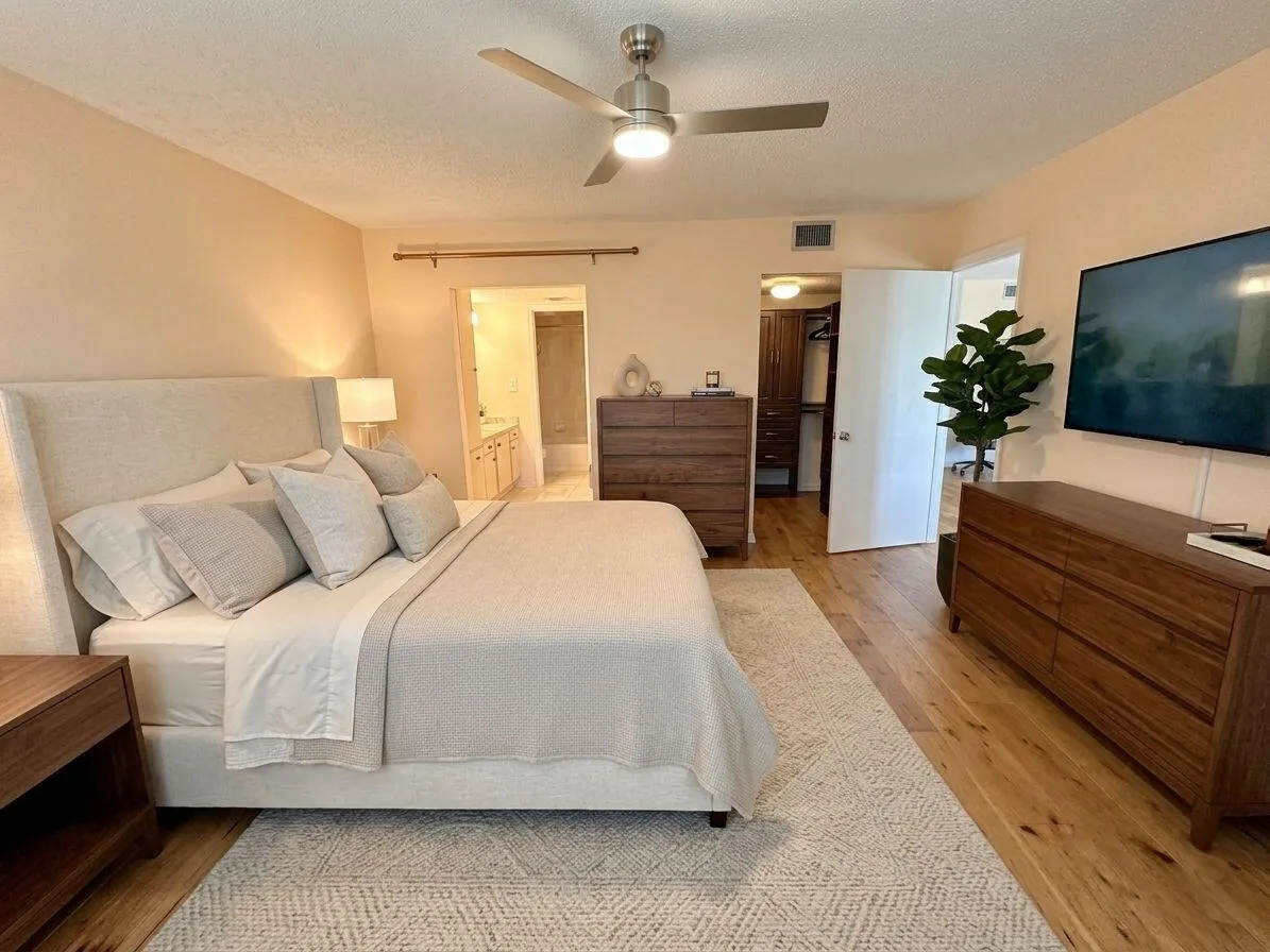 Digitally enhanced photo of Primary Bedroom. Virtually staged flooring and furniture.