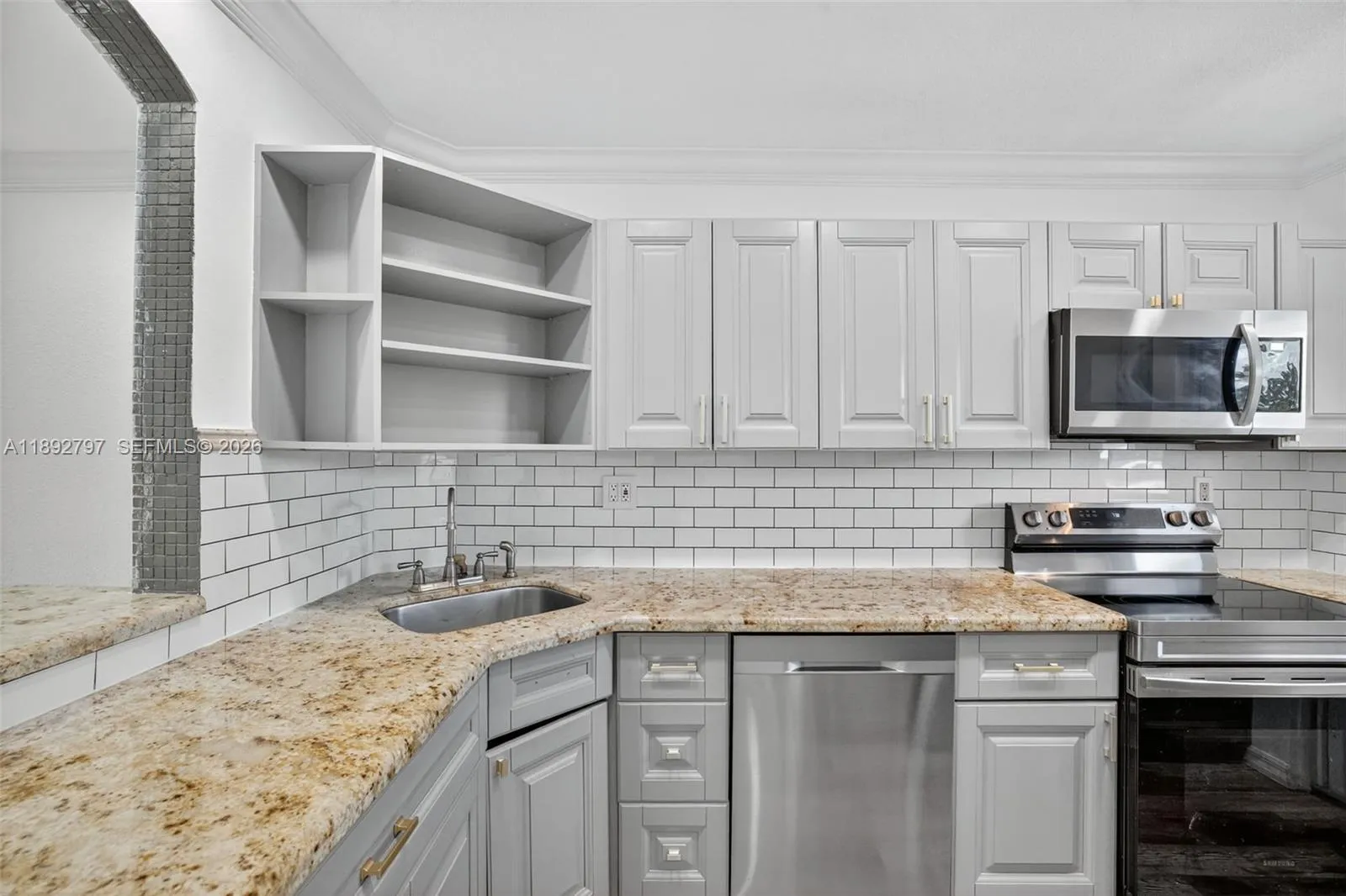 Open Concept Kitchen w/ newer stainless appliances, granite counter, updated cabinets and subway backsplash.
