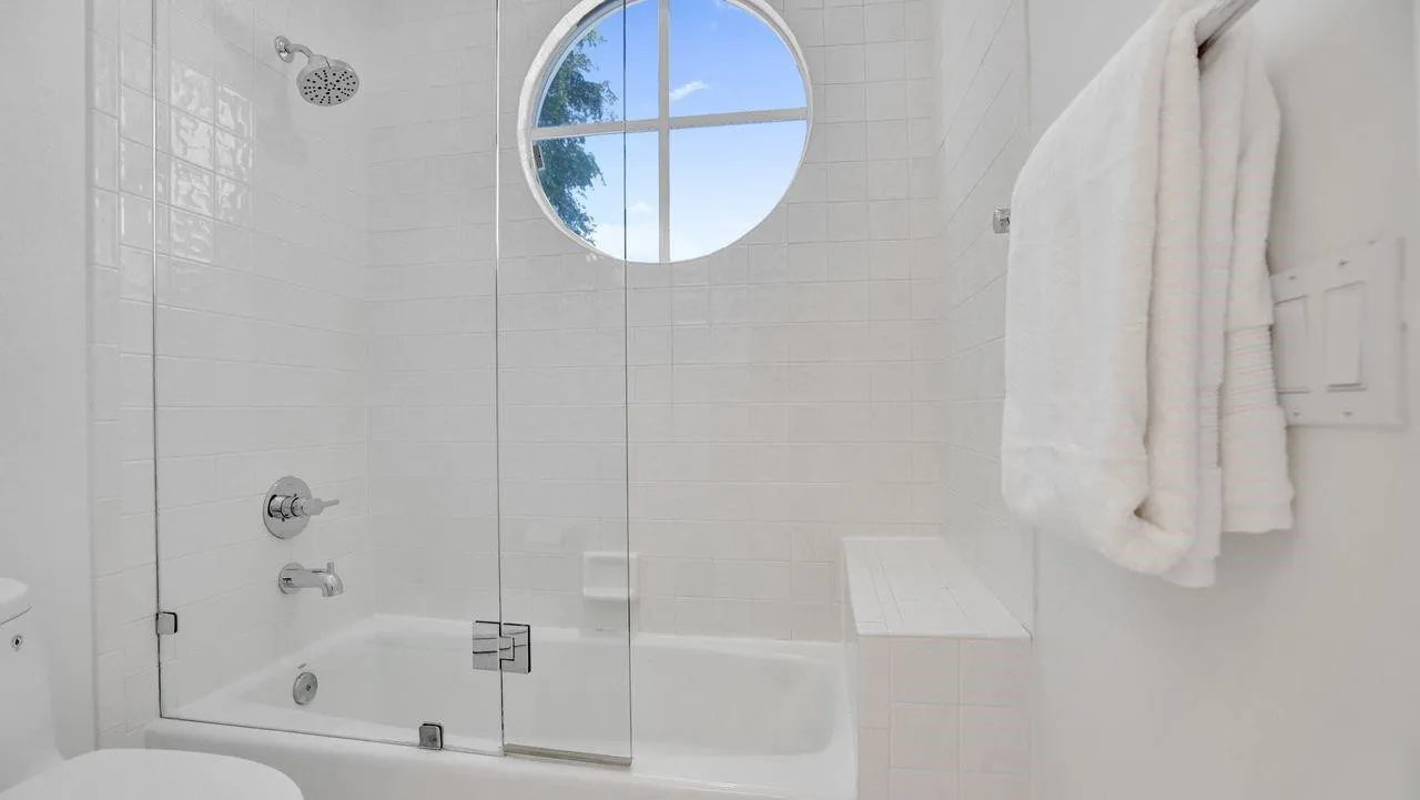 Seamless glass shower door with easy access to tub.