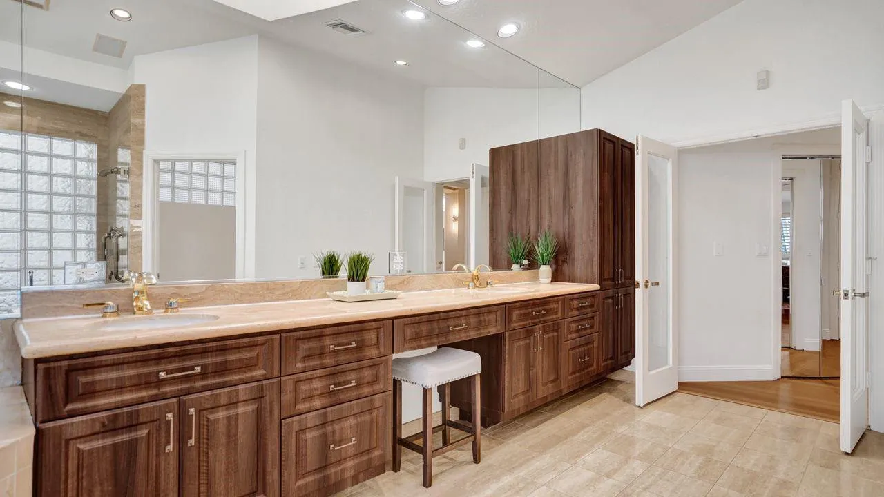 Custom cabinetry with custom built-in drawers, marble vanity, linen closet.