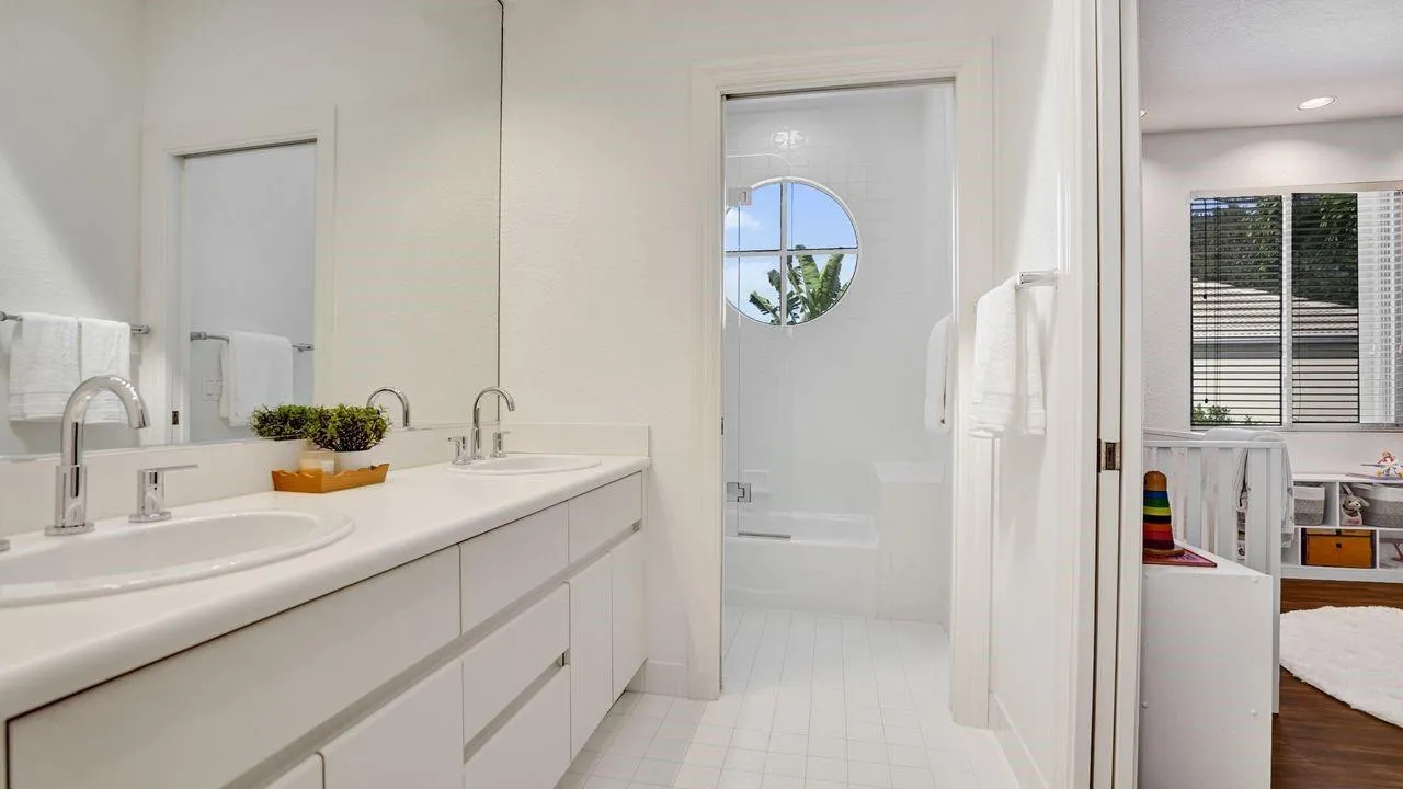Spacious pristine white on white bathroom with wide vanity.