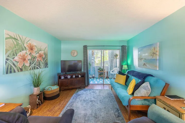 500 BONNIE BLVD 176 living room showcasing beautiful view to patio Florida room and laminate wood flooring throughout condo. Furnished with ease and space in mind.
