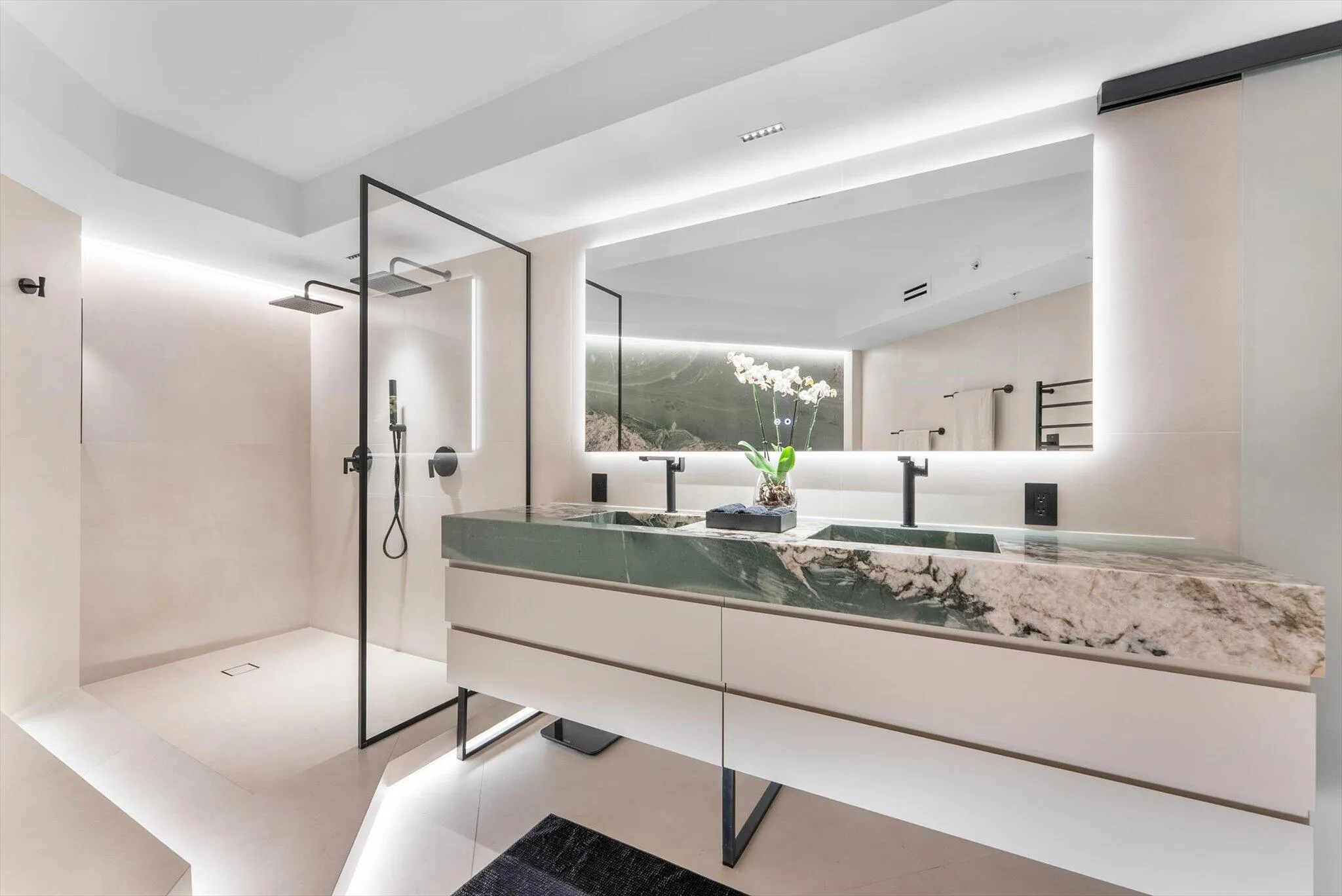 Primary Bathroom of elevated design with Intermare quartzite surfaces, 48x48 imported Spanish tile, and a custom-crafted tub wall that exudes
modern European luxury.