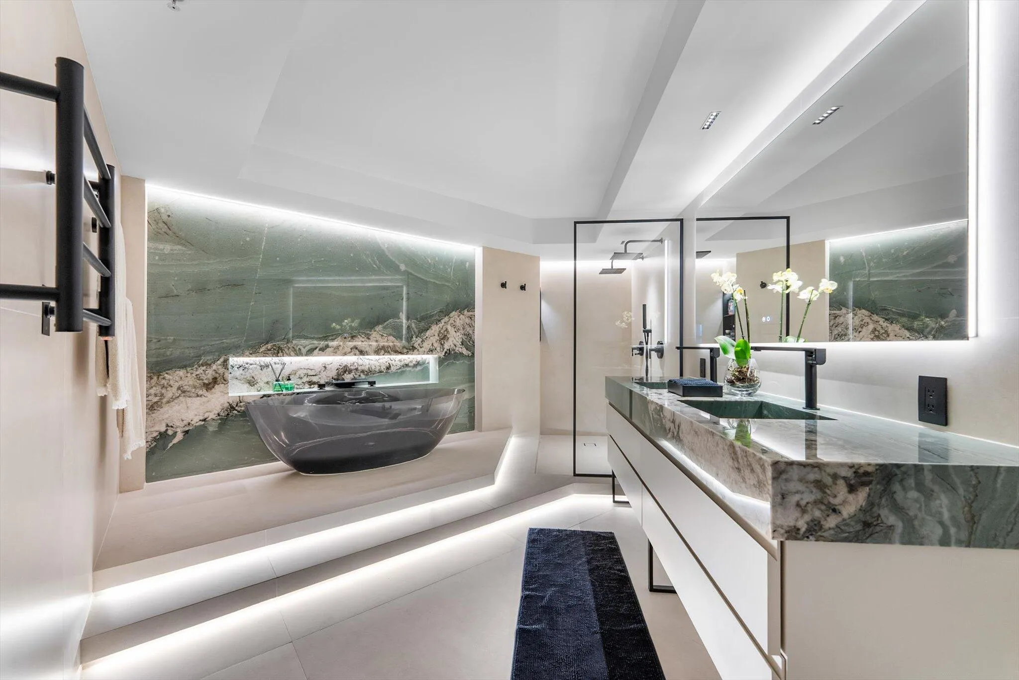 Primary Bathroom of elevated design with Intermare quartzite surfaces, 48x48 imported Spanish tile, and a custom-crafted tub wall that exudes
modern European luxury.
