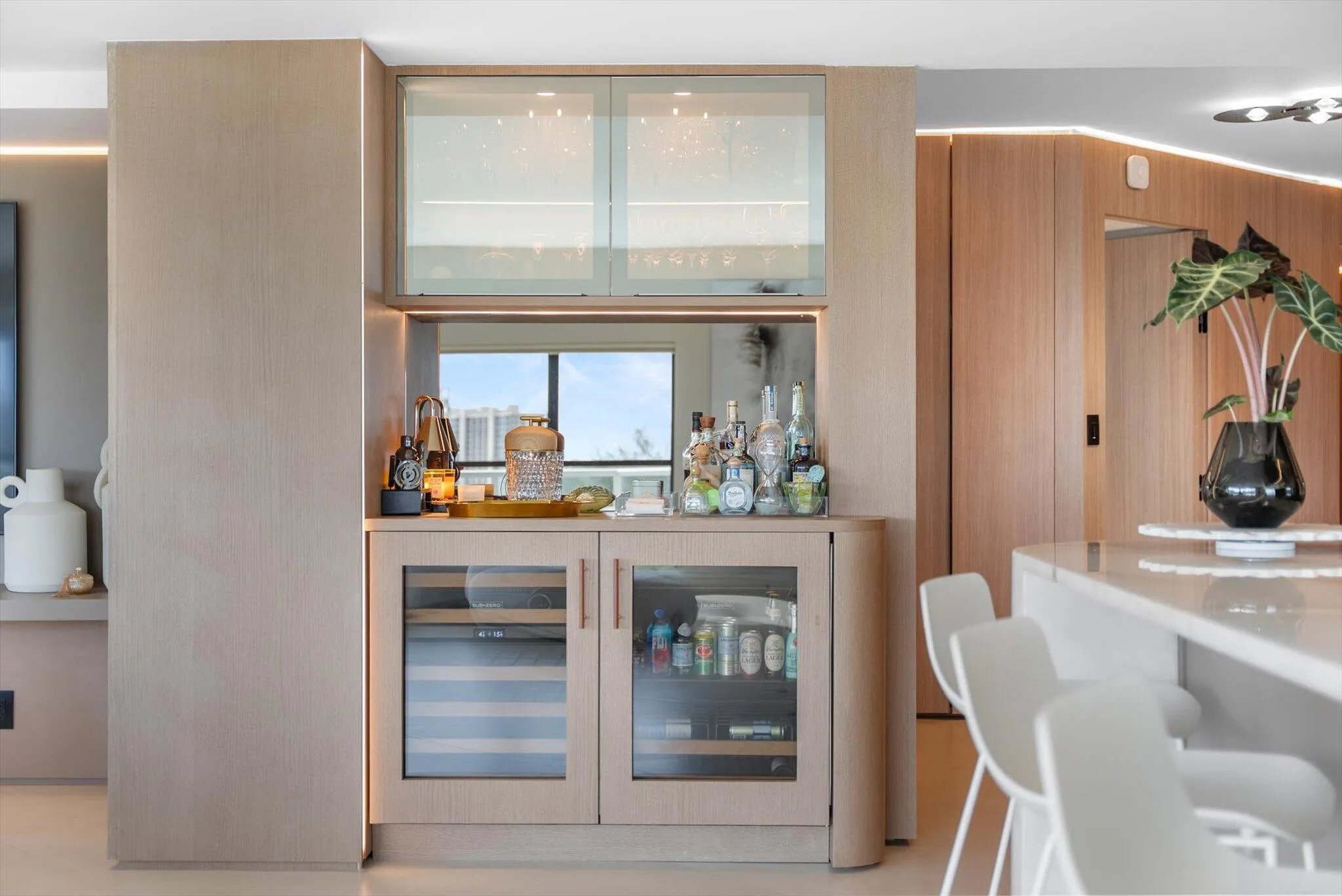 Wet bar with Subzero Wine Refrigerator and Beverage Center and Custom Wood and Glass Design