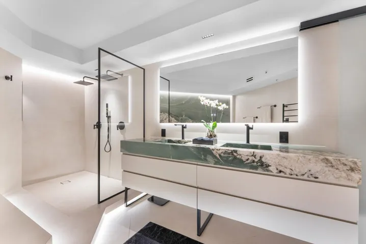 Primary Bathroom of elevated design with Intermare quartzite surfaces, 48x48 imported Spanish tile, and a custom-crafted tub wall that exudesmodern European luxury.