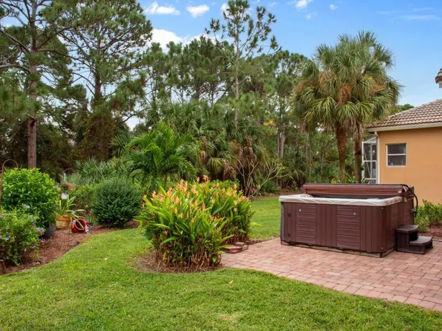 Hot tub resting on a paver patio that overlooks the butterfly garden and a patio