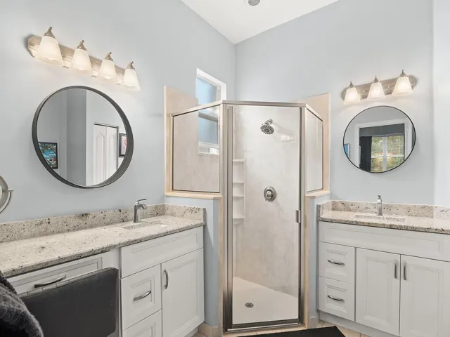 Owners en suite with two vanities and shower with grab bar