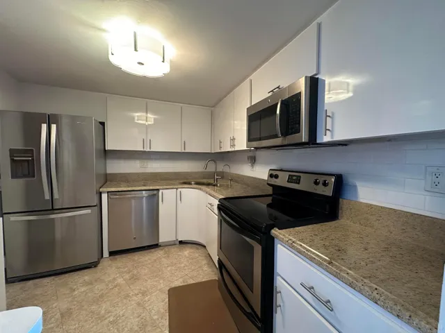 Bright white cabinetry and stainless appliances create a clean, coastal feel, effortless and welcoming