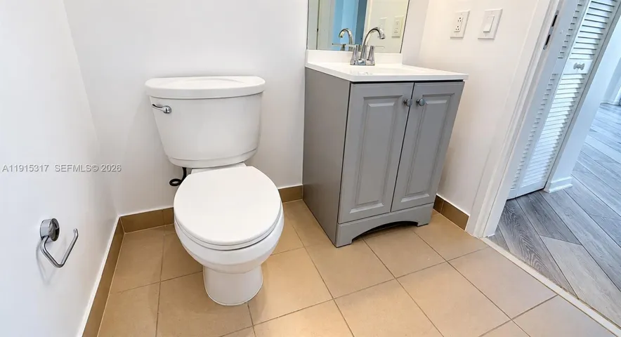 Tiled flooring, white walls, and a vanity with an integrated sink