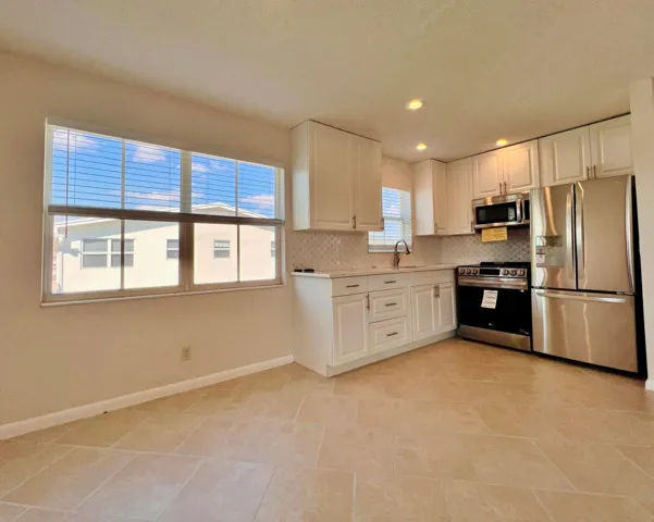 Beautifully Updated CORNER 2/1.5 With Pretty Water Views! NEW Updated & Open Kitchen. Updated Baths. Neutral Tile Flooring