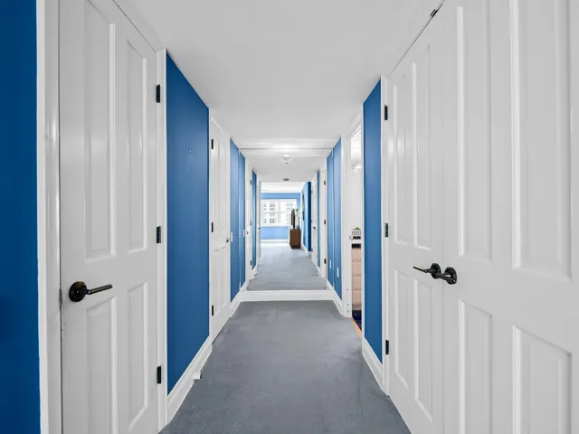 Primary suite hall to primary bath (note: wall mirror at the end of hall makes the hall look long)