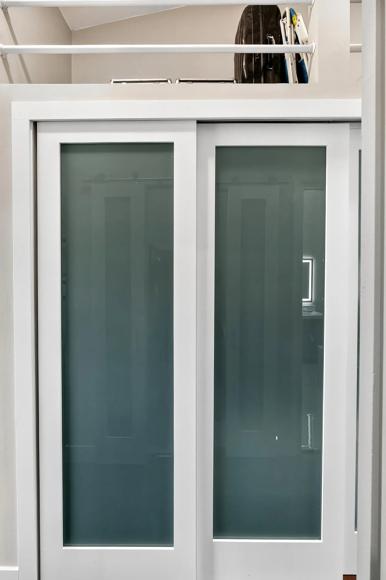 Primary Closet with Eight (8) Foot frosted glass doors with ample storage above
