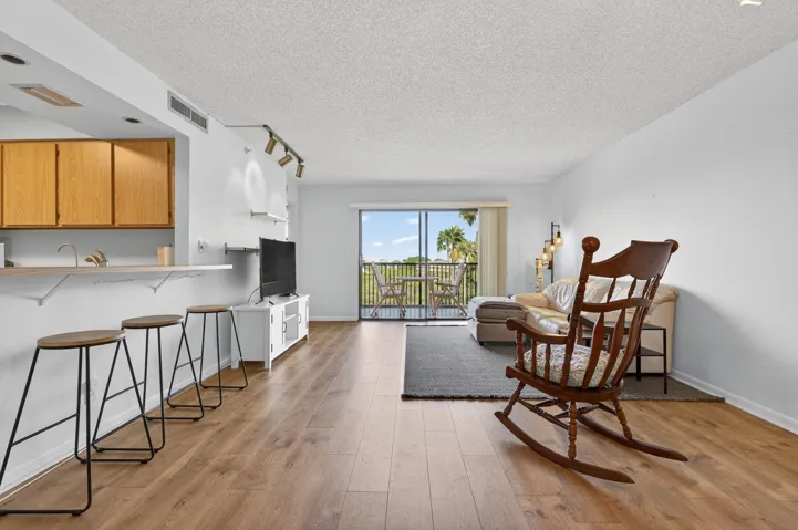 Light pours into this bright, beautiful living room, where you’re greeted with views of the pool, lake, and lush gardens. It’s the kind of space that just feels good the moment you walk in—airy, open, and full of natural charm.