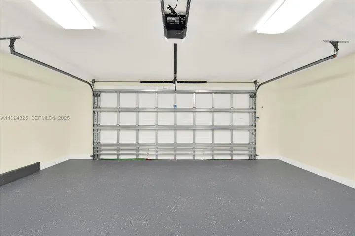 Two car garage with new epoxy floor and impact garage door in front and back.