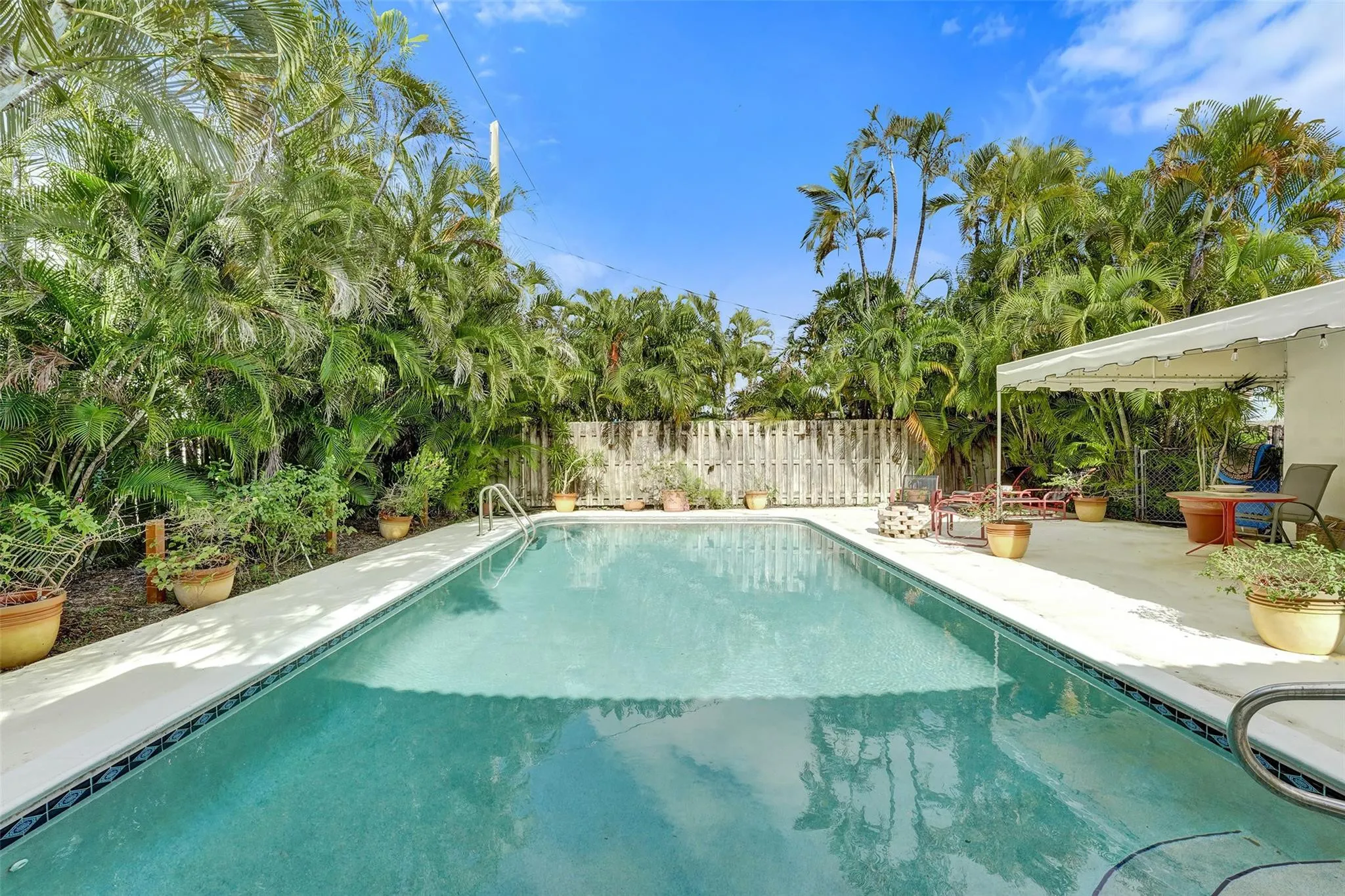 Huge sparkling pool surrounded by lush landscaping.