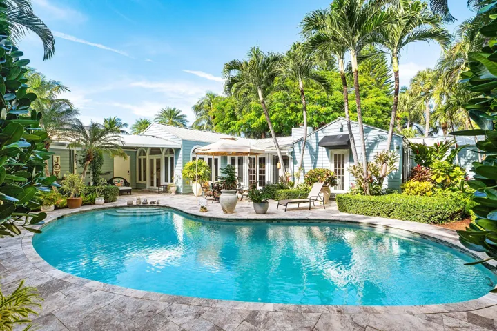 Outdoor patio with large pool and lush landscaping