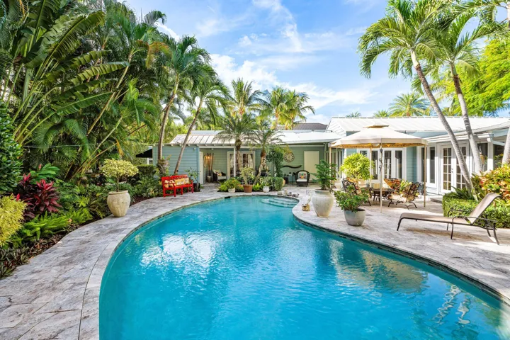 Outdoor patio with large pool and lush landscaping