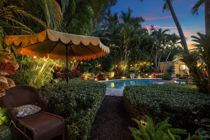 Outdoor patio with large pool and lush landscaping